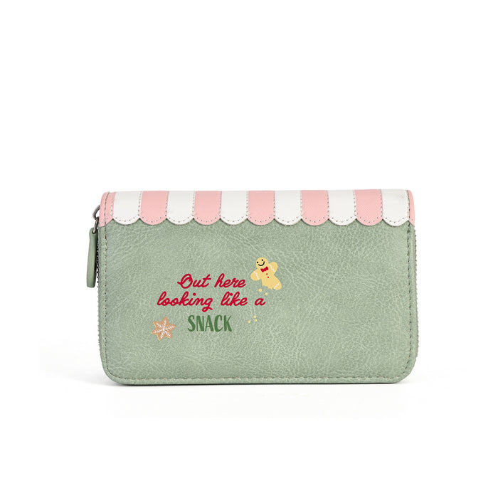 A mint green faux-leather zip-around wallet with a pink and white scalloped top border. The front features the text 'Out here looking like a SNACK' in red and green lettering, accompanied by a small yellow bee and orange flower graphic.
