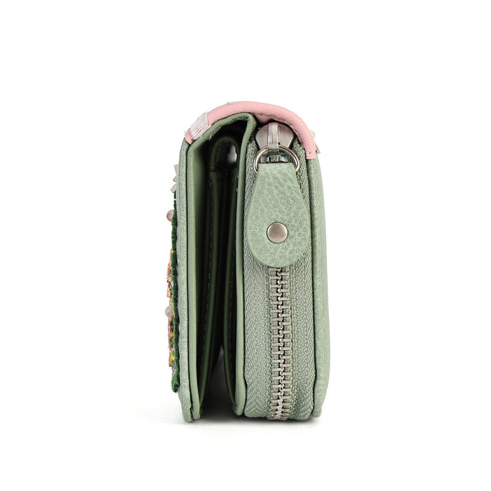 A mint green textured leather wallet shown from the side profile, featuring a pink leather trim at the top, a silver zipper, and a decorative floral embellishment on the side.