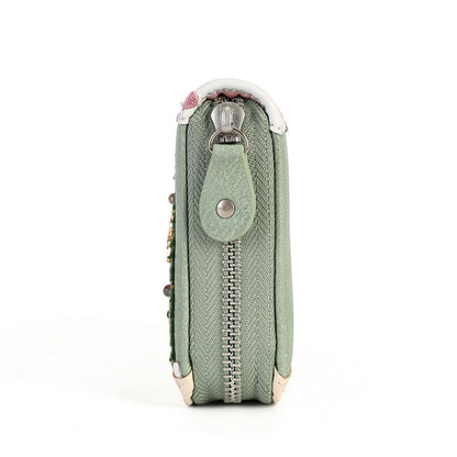 A sage green textured leather zippered pouch with a snap tab closure and silver metal hardware, shown from a side profile view on a white background.