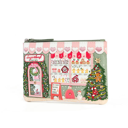 A rectangular zippered pouch featuring a festive Christmas market scene with a bakery storefront, gingerbread houses, a decorated Christmas tree, and a snowman, shown on a plain white background.