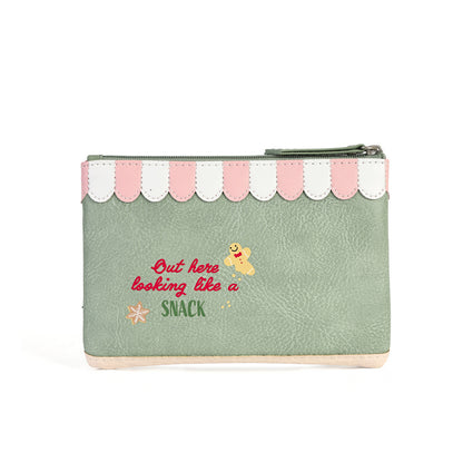 A mint green faux-leather zippered pouch with a pink and white scalloped top border. The front features a red embroidered quote reading 'But here looking like a SNACK' alongside a small yellow cartoon character and a tiny orange flower.
