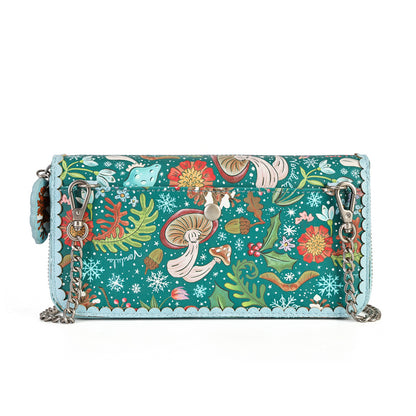 A rectangular shoulder bag with a vibrant, detailed fantasy illustration print featuring mushrooms, flowers, and fairies on a teal background, finished with a scalloped light blue border and silver-tone chain straps.
