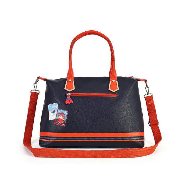 A navy blue faux leather tote bag with bright orange-red handles, trim, and a matching shoulder strap. The bag features a front zippered pocket with two decorative stickers, a top zipper, and a horizontal orange stripe near the bottom.