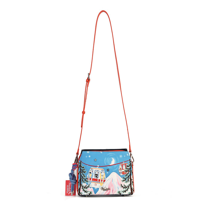 A colorful crossbody bag with a bright red strap, featuring a winter mountain scene printed on the front with a red snowmobile and blue sky background.