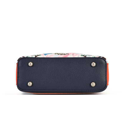 The bottom view of a handbag showing a navy blue pebbled leather base with silver metal studs, a colorful floral patterned fabric lining, and orange side trim, set against a plain white background.