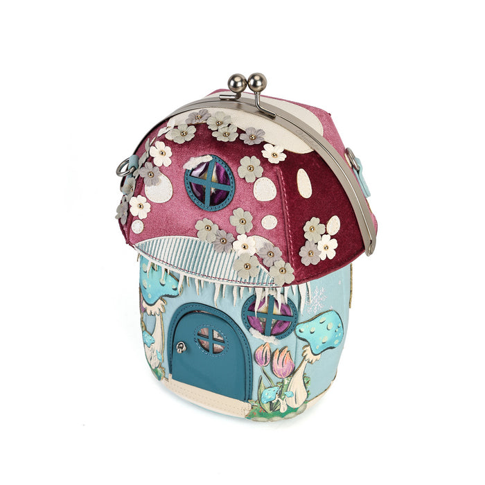 A novelty house-shaped crossbody with a secure clasp, detachable strap and compact main compartment. Printed and embossed vegan leather turns snowy toadstool houses, fairy doors, winter trees, rabbits and snowflakes into a playful winter woodland design.
