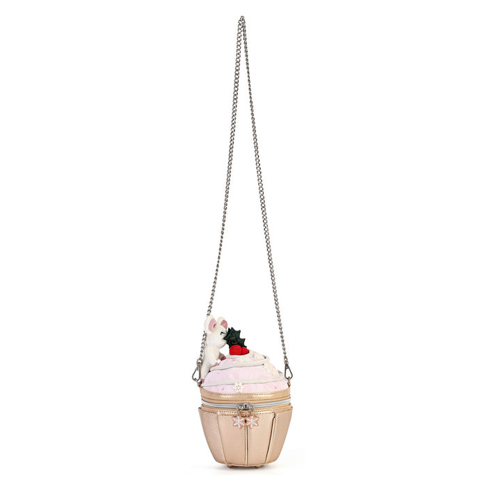 A whimsical cupcake-shaped shoulder bag in pale pink and beige, featuring a silver chain strap, a small white bunny, and a red strawberry decoration on top, set against a plain white background.