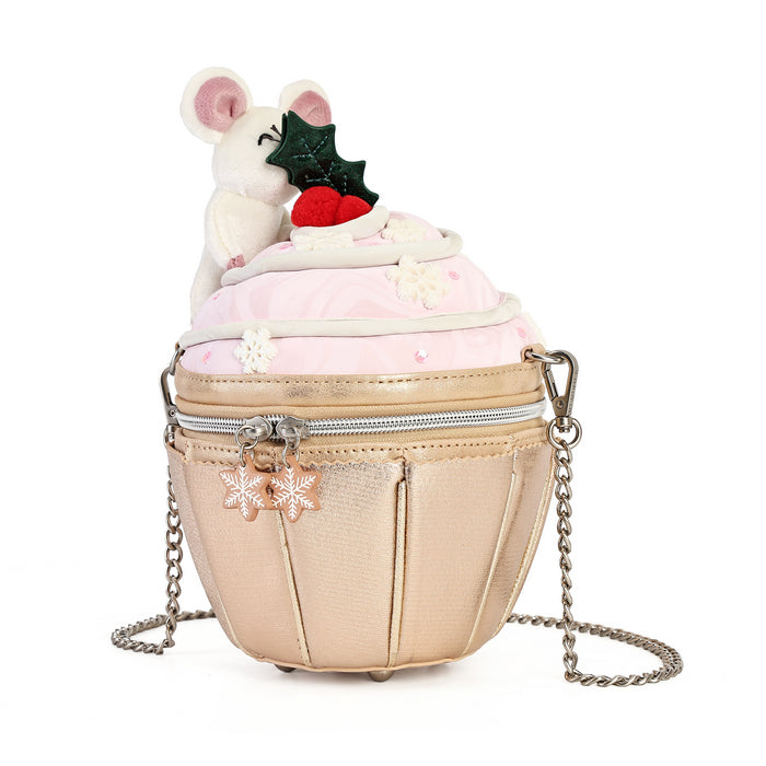 A cupcake-shaped shoulder bag with a metallic champagne gold body, a light pink frosting top, and a white mouse decoration holding a holly sprig on top. The bag has a silver zipper, a pink snowflake charm, and a silver chain strap, shown on a plain white background.
