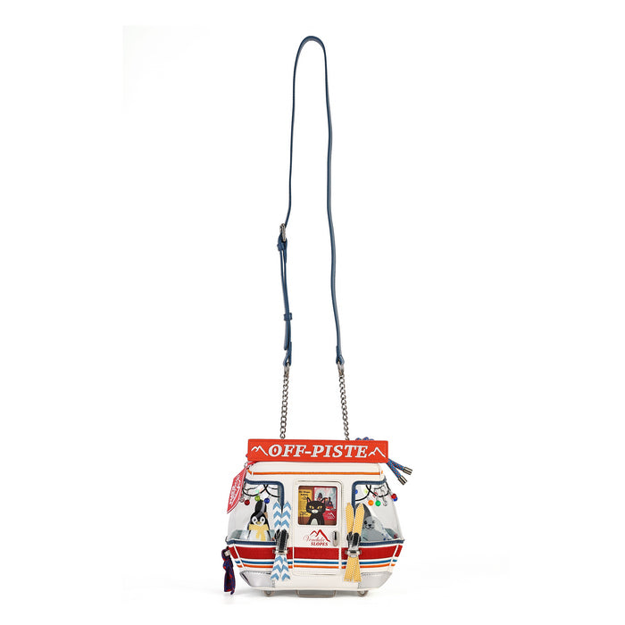 A small crossbody bag with a blue strap and a colorful printed front panel featuring a red 'OFF-PISTE' banner and illustrated details, shown on a plain white background.
