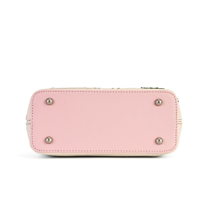 The bottom view of a light pink leather handbag, showing a smooth pink base with four silver metal studs and a beige stitched edge, on a white background.
