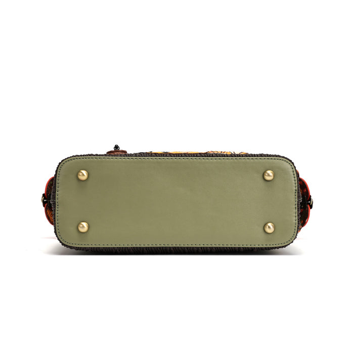 The bottom view of a structured handbag in olive green leather, featuring four gold-tone metal studs on the front and sides, a dark textured trim, and a hint of a patterned strap at the top, set against a plain white background.