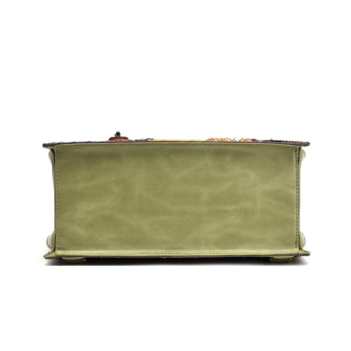 A sage green leather clutch purse shown from the back, featuring a textured leather back panel, stitched edges, and a small decorative clasp on top, set against a plain white background.