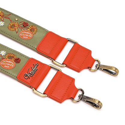 An olive green embroidered shoulder strap with bright orange-red leather panels and antique brass hardware, featuring floral embroidery and the brand name 'Vivabella' on a white background.