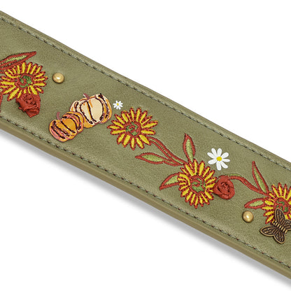 An olive green leather strap featuring detailed autumn embroidery with sunflowers, pumpkins, roses, a butterfly, and small white daisies, accented with brass studs, shown on a white background.