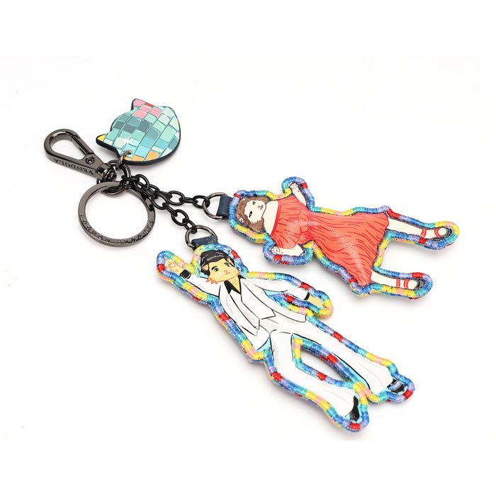 A novelty keychain featuring two small acrylic charms shaped like a man in a white suit and a woman in a red dress, attached to a black chain with a disco ball key fob on a white background.
