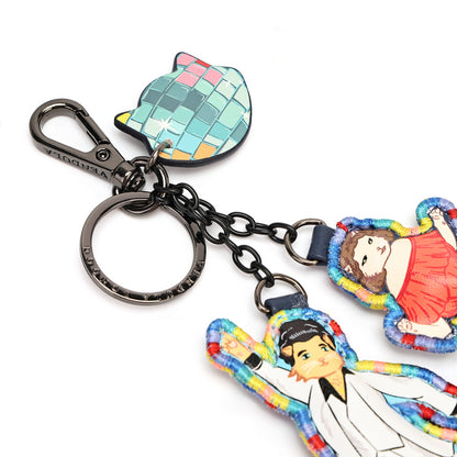 A colorful keychain featuring a cat-shaped disco ball charm, a black metal clasp and chain, and two illustrated character charms on a plain white background.