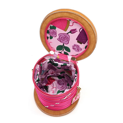 An open round cylindrical storage box or case with a pink floral patterned interior and a tan leather-like exterior, shown on a plain white background.
