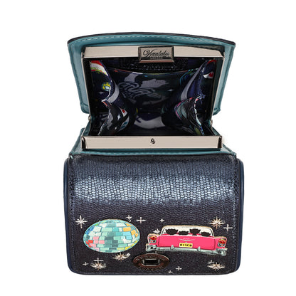 An open black crocodile-embossed clutch wallet by Dolce & Gabbana, featuring a turquoise interior lining, a colorful disco ball patch, and a pink classic car patch on a white background.