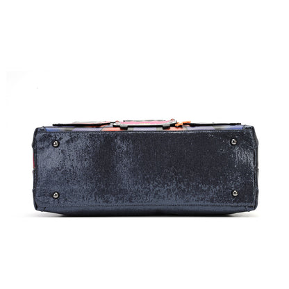 A dark navy blue velvet rectangular clutch bag shown from the back, featuring a textured velvet finish, silver metal studs, and a colorful patterned lining visible along the top edge, set against a plain white background.