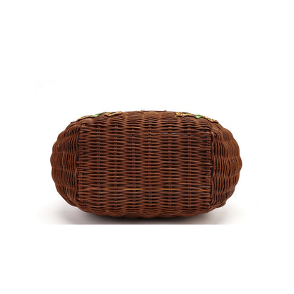 A brown woven wicker clutch bag with a rounded rectangular shape, shown from the bottom on a white background.