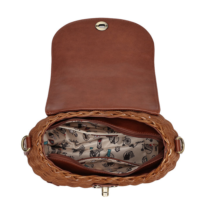 An open brown leather and woven straw handbag shown from above on a white background, revealing a patterned interior lining with small illustrated motifs and gold-tone hardware.