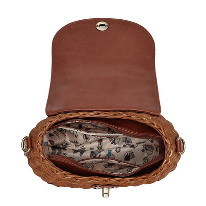 An open brown leather and woven straw handbag shown from above on a white background, revealing a patterned interior lining with small illustrated motifs and gold-tone hardware.