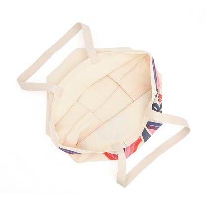 An open canvas tote bag with a cream-colored interior and a multicolor patterned exterior featuring red, blue, and white stripes, shown on a plain white background.