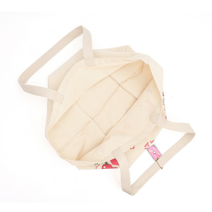 A cream-colored canvas tote bag with a floral print visible on the bottom right, shown from a top-down view on a white background.