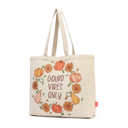 A cream-colored canvas tote bag featuring a circular autumn-themed illustration with pumpkins, sunflowers, pears, and the text 'GOUD VIBE'S ONLY' in brown lettering, shown against a plain white background.