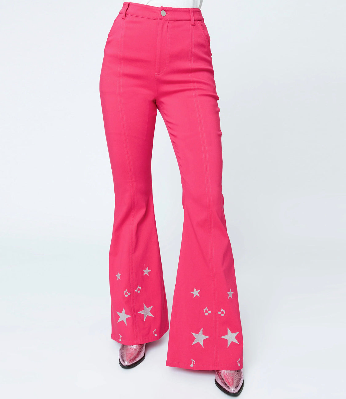 These sensational 1970s style bell bottoms are crafted in a bright pink bengaline stretch with contrast seaming and glittery stars on the flare legs. The banded high waist is cinched with a front zipper and button, outfitted with side and back pockets for modern function!