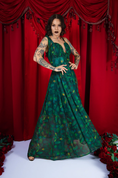 Woman in a green dress posing against a red curtain backdrop