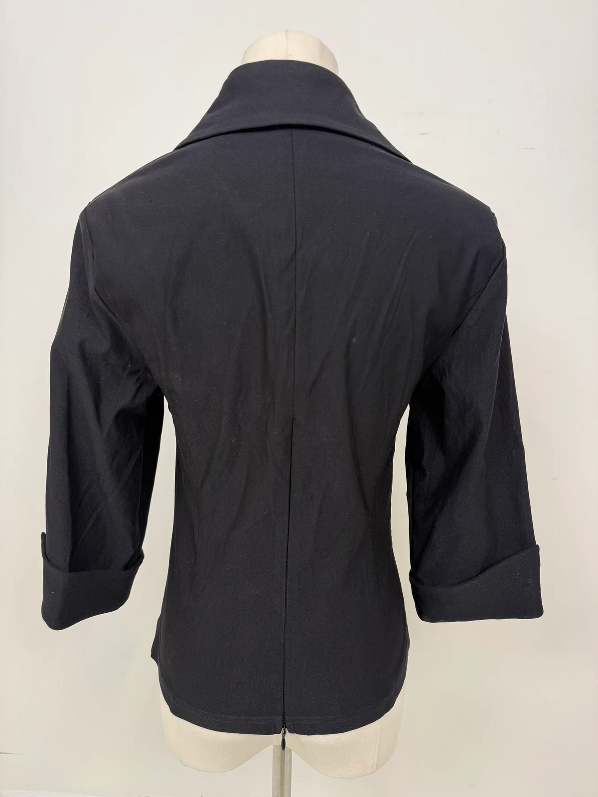 A dark charcoal gray women's blazer shown from the back on a mannequin torso, featuring a pointed collar, three-quarter sleeves with rolled cuffs, and a center back seam.