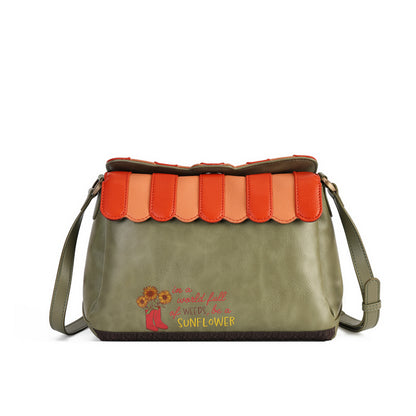 An olive green faux-leather shoulder bag with a scalloped orange and peach leather top flap, featuring a printed sunflower and the phrase 'It is worth a little hurt to weed out a SUNFLOWER' on the front.