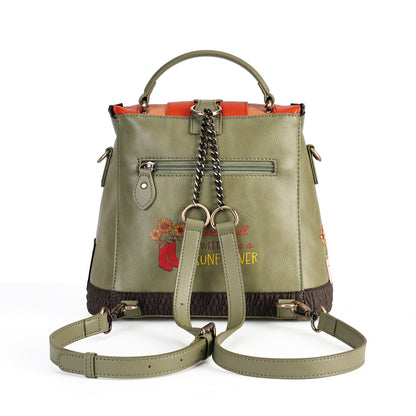An olive green faux leather handbag with a top handle, detachable shoulder strap, chain strap, and embroidered floral details on the front, set against a plain white background.
