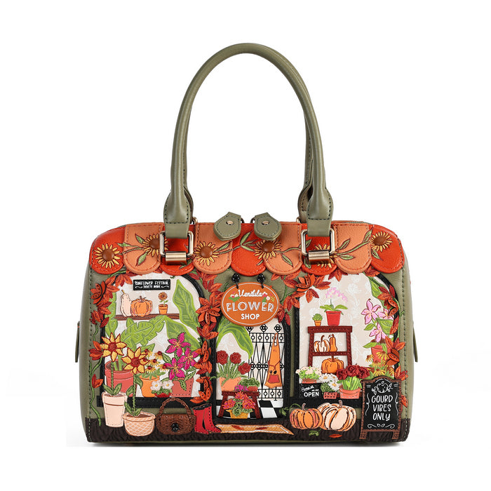 A structured handbag with olive green handles and trim, featuring a highly detailed, colorful autumn-themed illustration on the front depicting a flower shop, pumpkins, and fall foliage.
