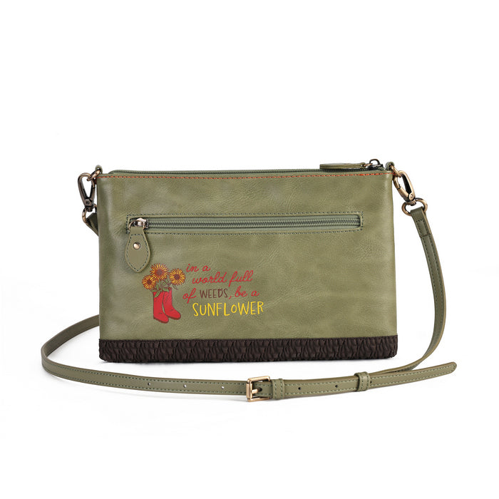An olive green faux-leather crossbody bag with a front zippered pocket, featuring a red and yellow 'Sunflower' quote and cowboy boots graphic on the front, with a dark brown textured bottom trim and a matching shoulder strap.