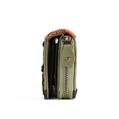 A side profile view of a small wallet or clutch in olive green textured leather with a gold-tone zipper, a snap button closure, and a patterned orange and black fabric lining at the top, shown on a plain white background.