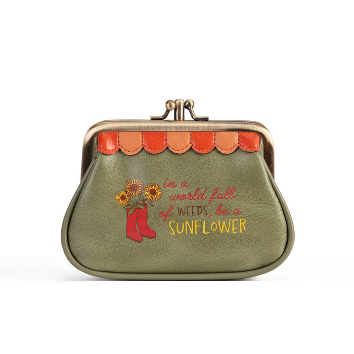 An olive green faux leather kiss-lock coin purse with a scalloped orange and brown trim, featuring a red rain boot and sunflower graphic with the text 'in a world of weeds, be a SUNFLOWER' in red and yellow lettering.