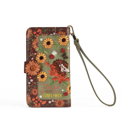 A wallet phone case with a wrist strap, featuring a rustic floral and hedgehog illustration on an olive green background with brown and orange accents.
