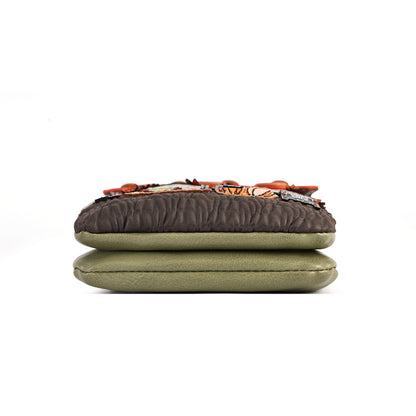 A handmade quilted cushion with a dark brown top layer, an orange and black patterned band, and a solid olive green bottom layer, shown on a plain white background.