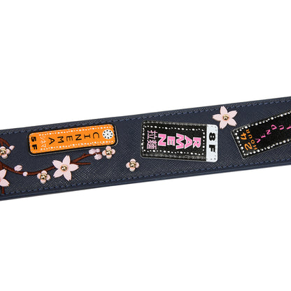 Decorative belt with floral elements and brand labels on a white background