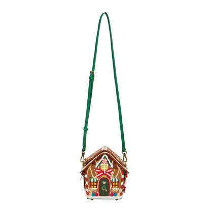 Gingerbread house-shaped handbag with a green strap on a white background