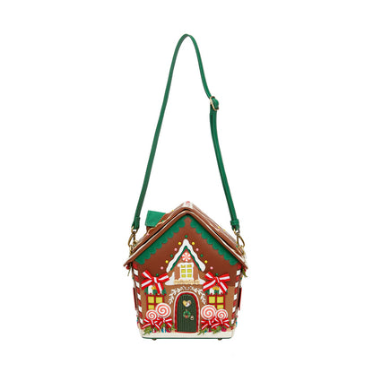Gingerbread house-shaped handbag with a green strap on a white background