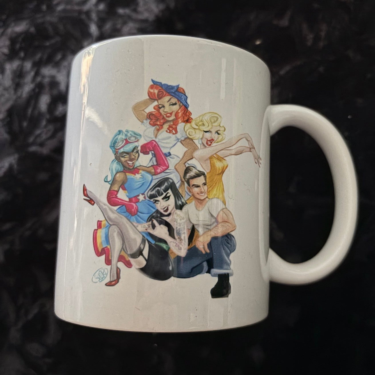 Mug with colorful illustrations of people on a black textured background