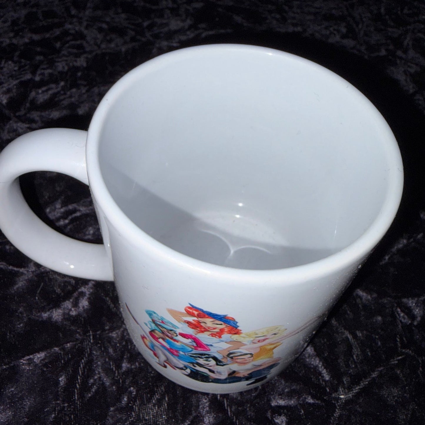 White mug with colorful design on a dark textured surface