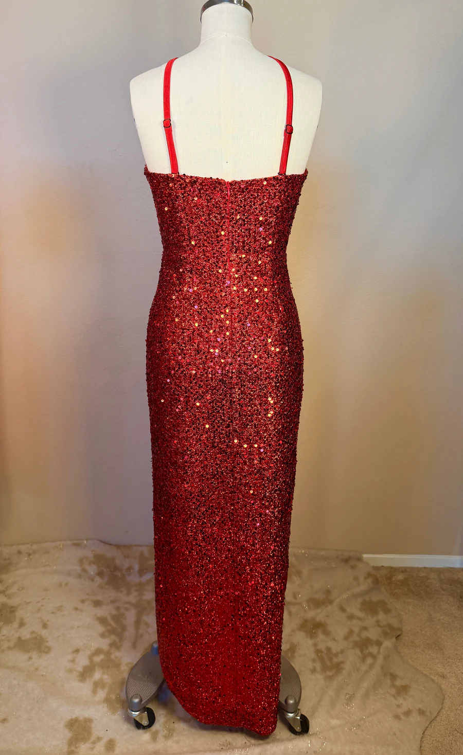 Red sequin dress on a mannequin against a plain background