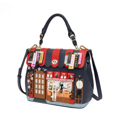 Handbag with a detailed design of a building facade and street scene on a white background