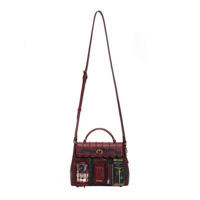 Brown leather handbag with decorative elements on a white background