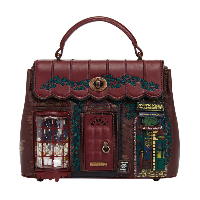 Decorative handbag with a house design and small door, featuring intricate details on a white background.