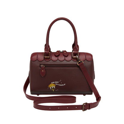 Brown handbag with scalloped edge design on a white background